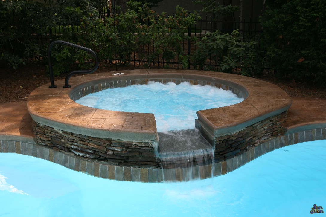 Catalina Fiberglass Pool with stamped and stained concrete on raised wall with water fall