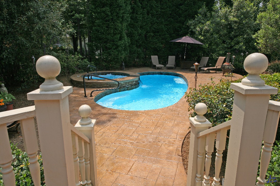 Catalina Fiberglass Pool with travertine pavers and raised spa waterfall