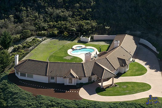 atlantic pool shape behind large curved house in large field