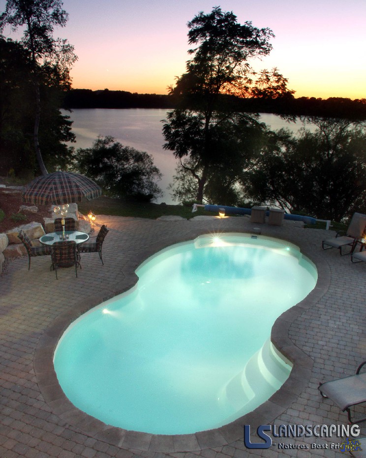 atlantic pool shape with brick pavers outdoor patio next to lake