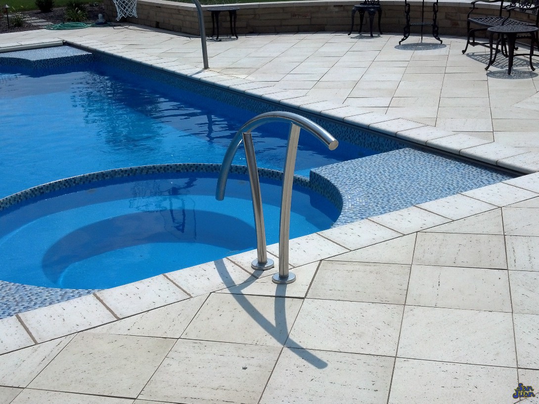 ceasars palace fiberglass pool shape with natural travertine decking and handrail with tile finish