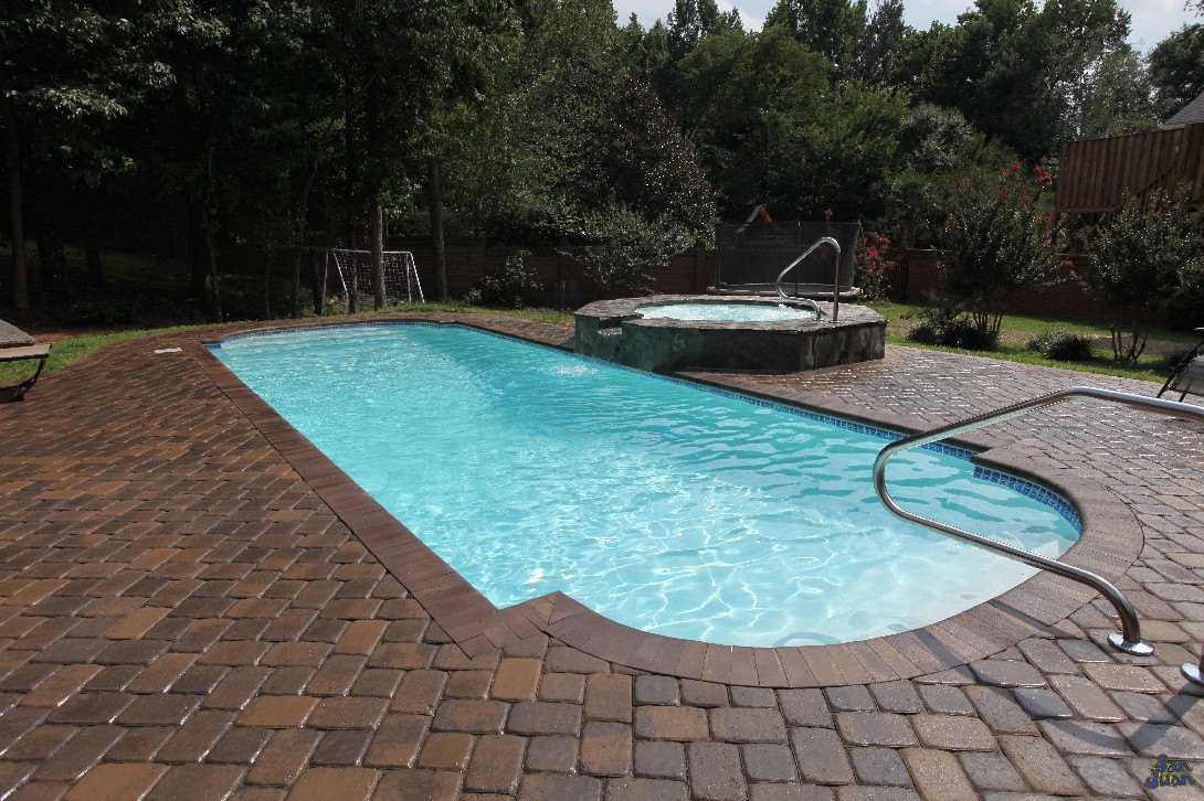 This dolphin pool is complimented by a nice brick paver deck, shallow end handrail & raised spa. For those who may not know, we also sell fiberglass spas and will have much more articles to follow on those in the future!