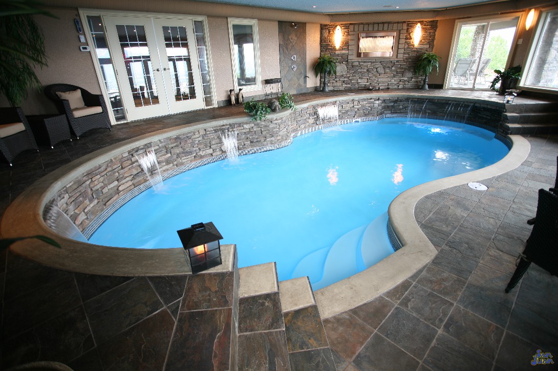 fiberglass pool installed inside home with waterfalls