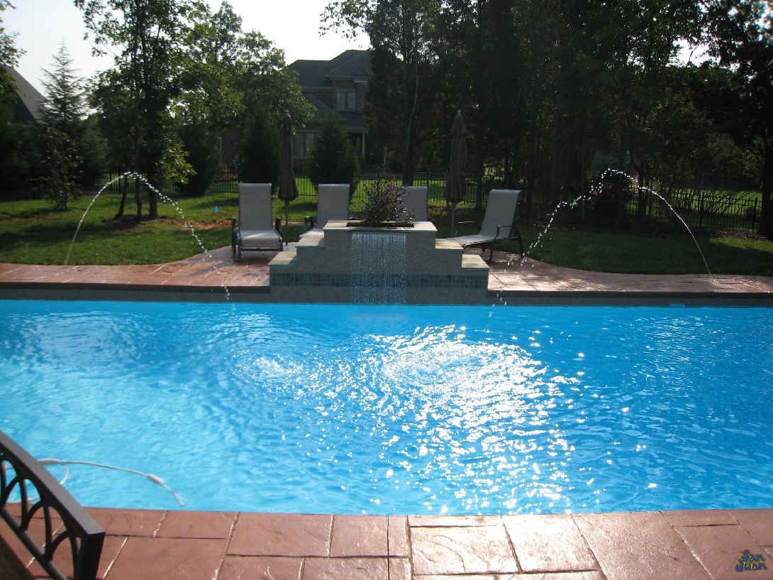 pacific fiberglass pool with raised waterfall and deck jets