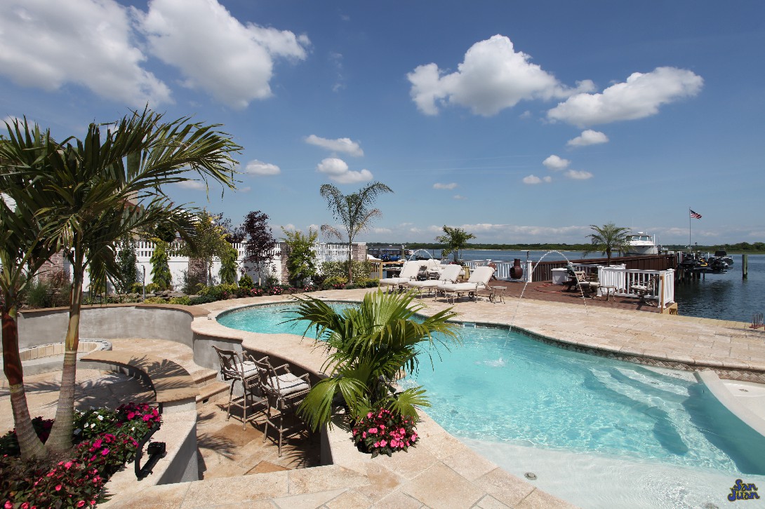 pleasure island fiberglass pool shape with attached spa and raised waterfalls next to outdoor kitchen (2)