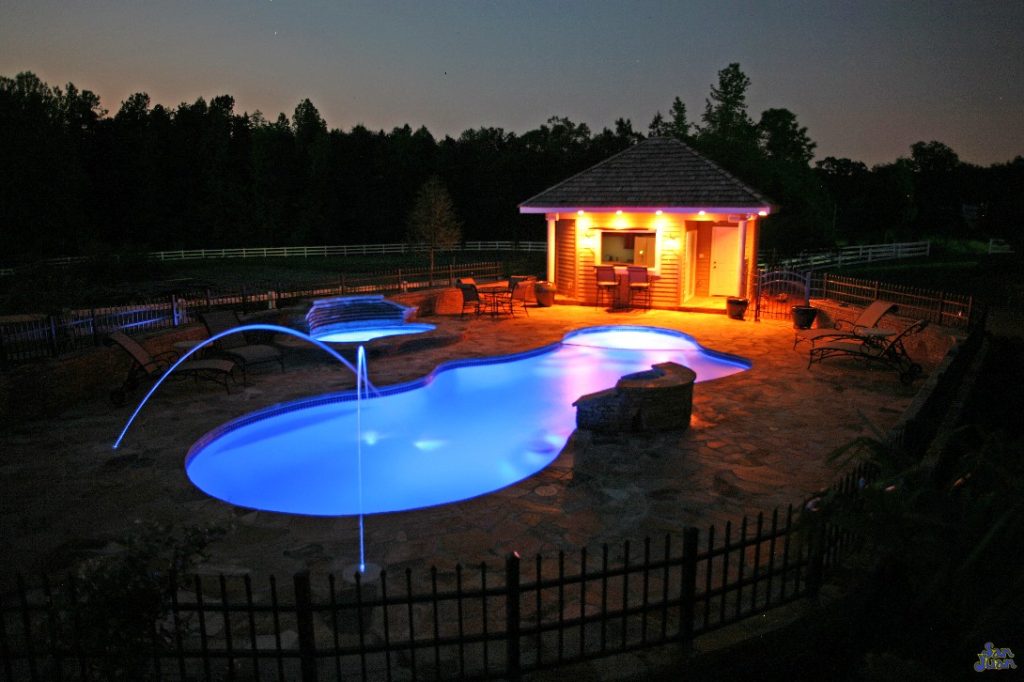 pleasure island fiberglass pool shape with led laminar technology at night