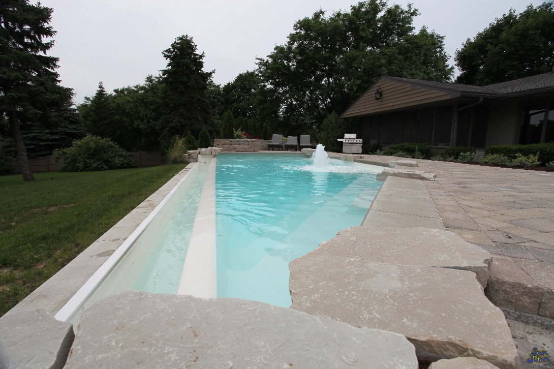 A splash pad bubbler, negative edge waterfall, sharp corners and swim up seating - what else can this amazing pool offer? We give you all of the fun design options up front so you don't have to think of new ways to spiff up your pool. We like to be turn-key like that. You give us the call, we bring the fun, and summer commences!