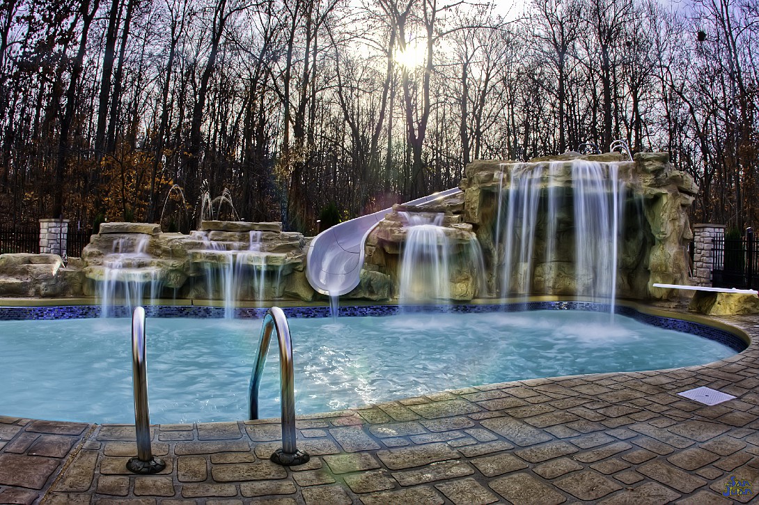 Wow! That's a stunning view! We love looking at amazing pictures like this because it reminds us and our customers that this is achievable for your own backyard! What we're looking at here is a pair of raised grotto waterfalls tied into a secondary water feature pump. It's simple enough in design but absolutely gorgeous to look at!