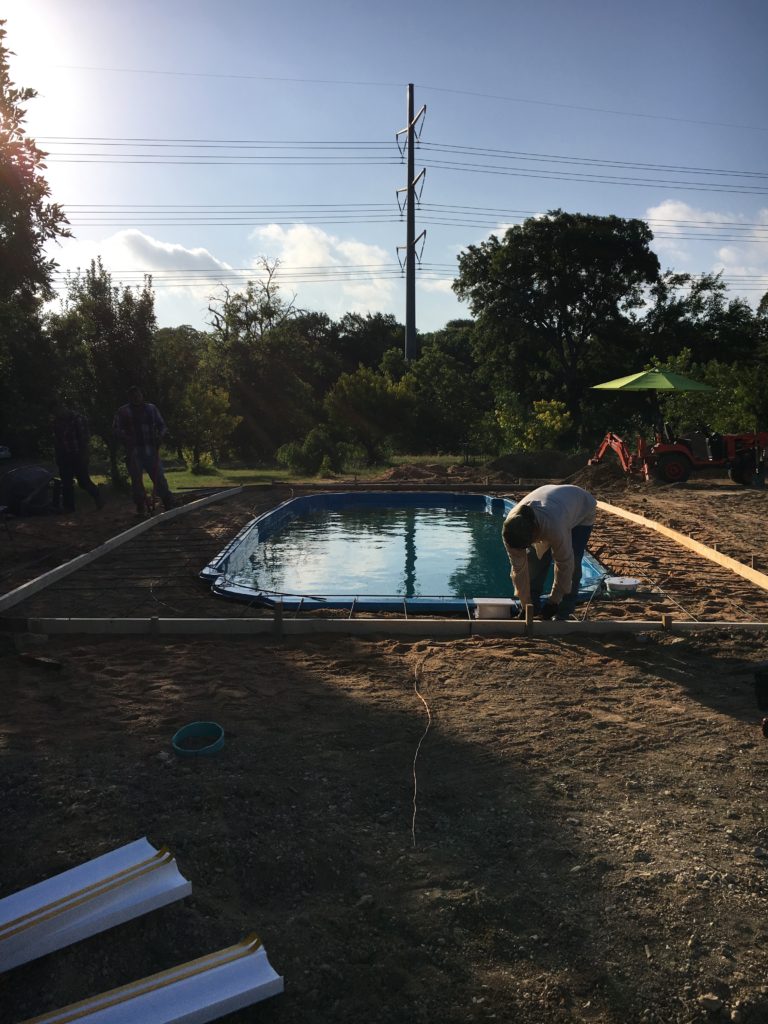 To start up, what you are seeing here is the arrival of our concrete crew. They are currently prepping our fiberglass pool to have a concrete deck put in. They show up at the crack of dawn to lay the "steel" (rebar) in a 12"x12" perimeter around our swimming pool. Once the steel is tied, they begin the process of pouring our concrete deck.