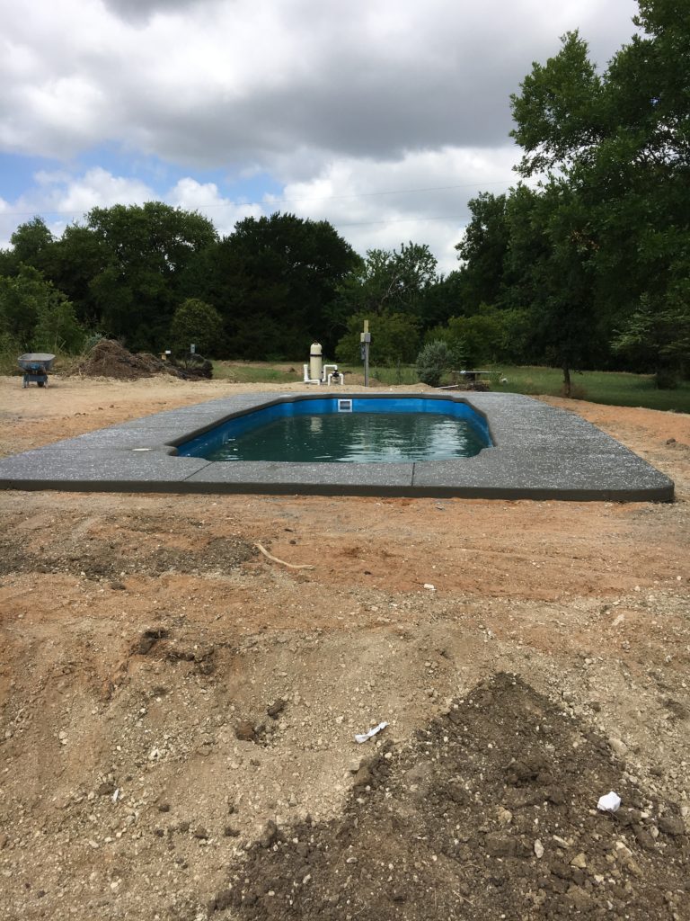 This is an image of our poured concrete deck - just resting and allowing it time to dry. We use some pretty amazing crews that have the capability of creating stamped, stained or textured concrete. This swimming pool is set with rock salt that dissolves to provide a natural texture to the concrete. More to come on this next week...