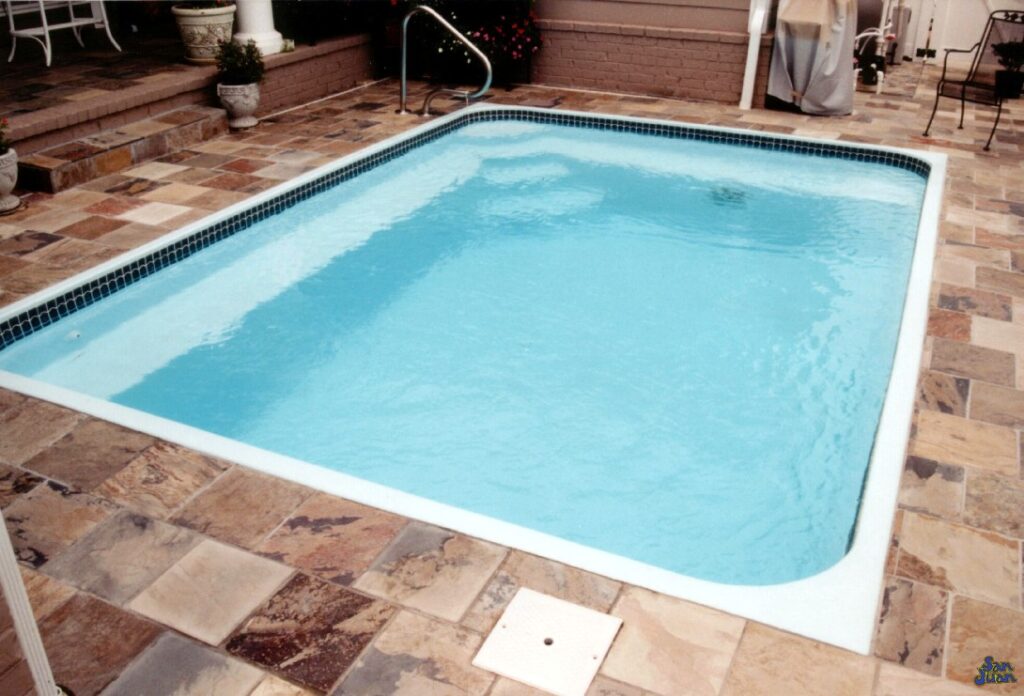 Here you can see the wide bench on the left and right side of the Corner Entry Steps for The Sea Isle swimming pool. This elongated bench provides the perfect space to relax and entertaining for those hot summer evenings outdoors! 